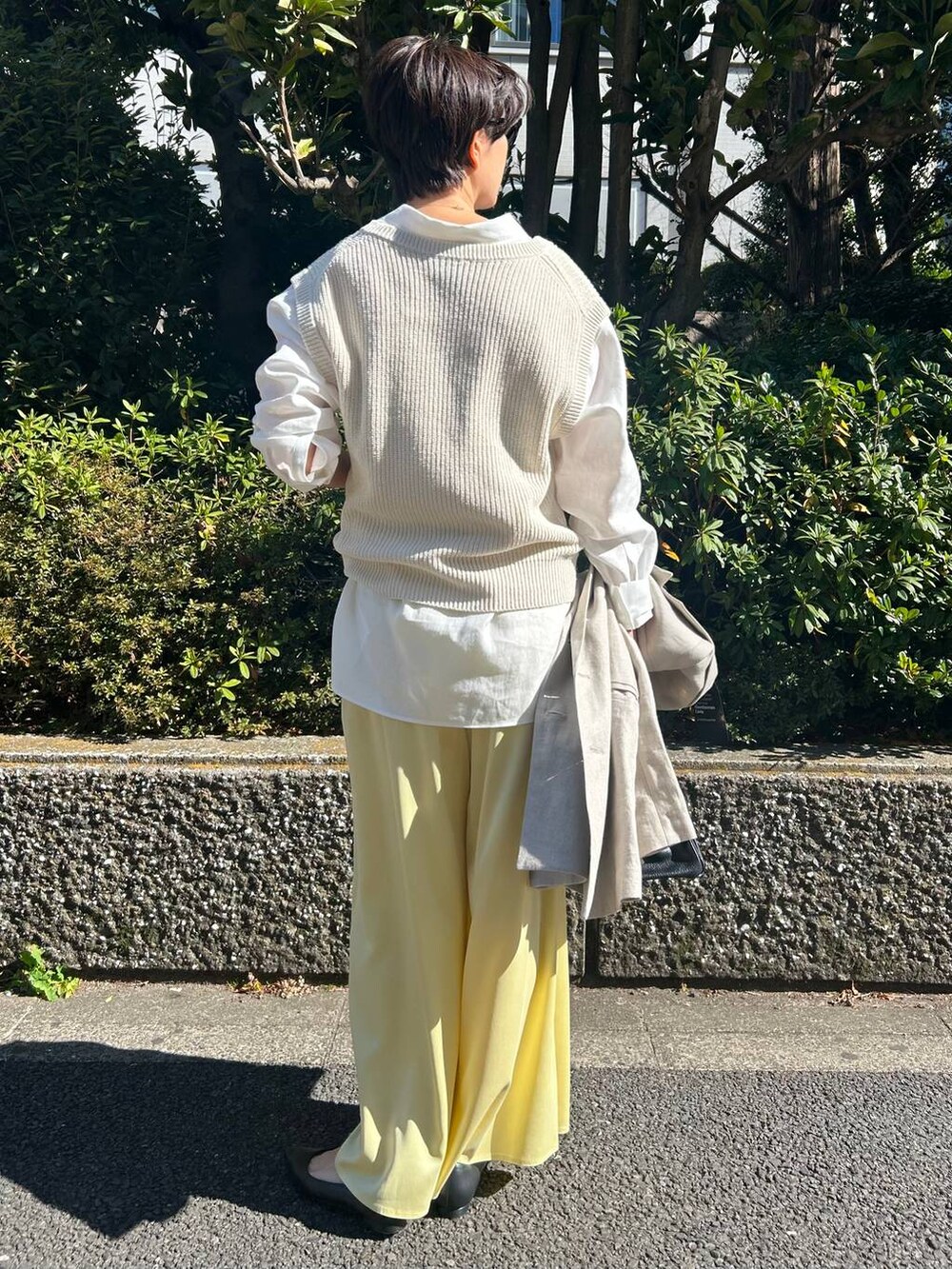 イエロー系のその他パンツ、ホワイト系のベスト、ベージュ系のテーラードジャケットを着用したレディースの冬コーディネートの4枚目の写真