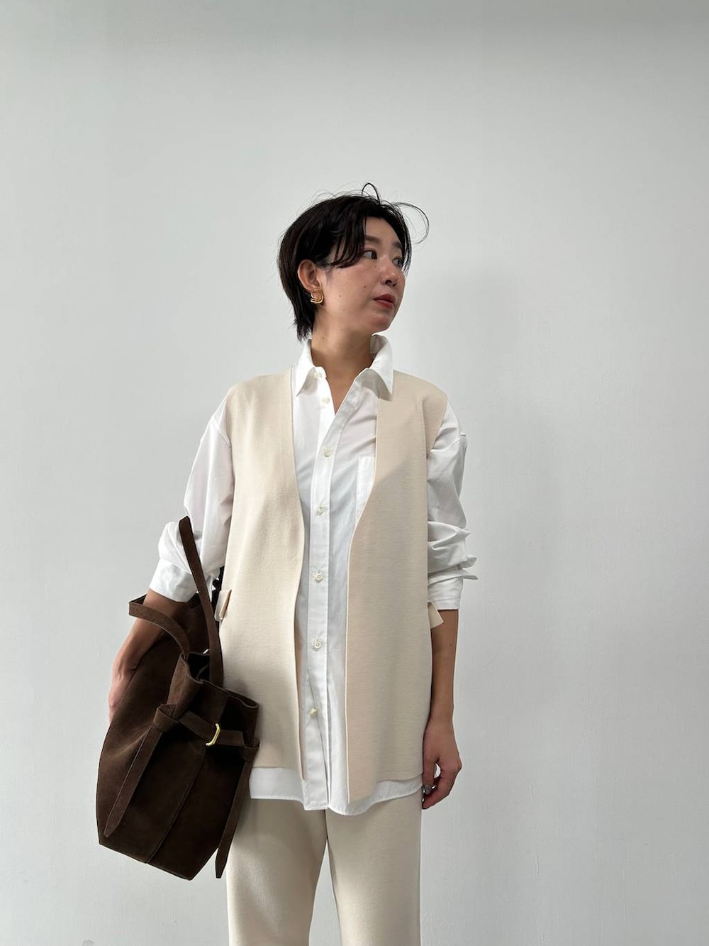 ホワイト系のシャツ/ブラウス、ベージュ系のベスト、ベージュ系のブルゾンを着用したレディースの冬コーディネートの6枚目の写真