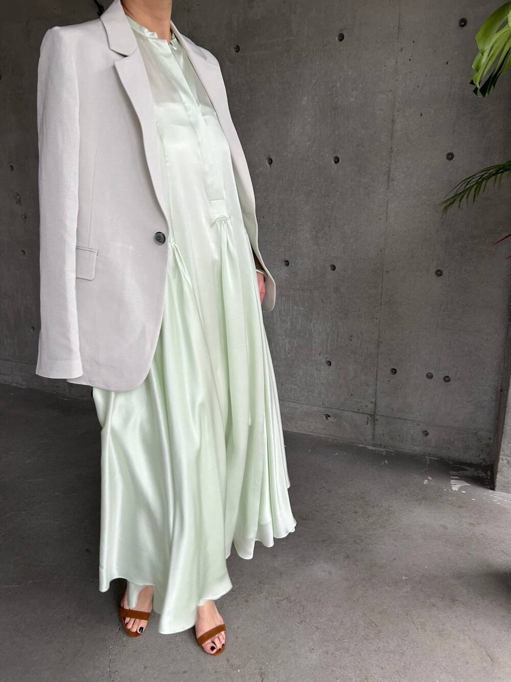 ホワイト系のキャミソール、グリーン系のワンピース、グレー系のテーラードジャケットを着用したレディースの春コーディネートの7枚目の写真