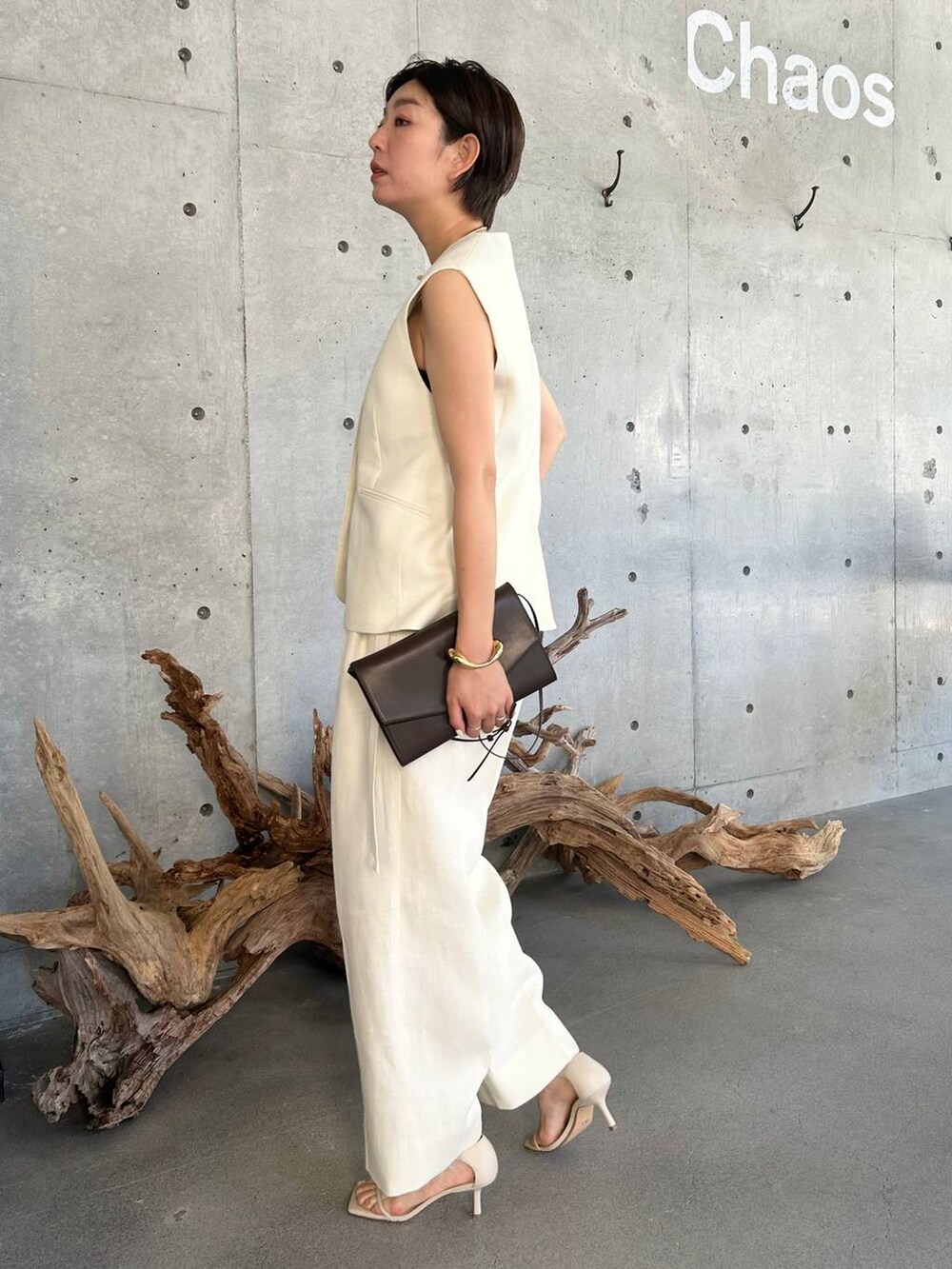 ブルー系のキャミソール、ベージュ系のサンダル、ホワイト系のスラックスを着用したレディースの夏コーディネートの3枚目の写真