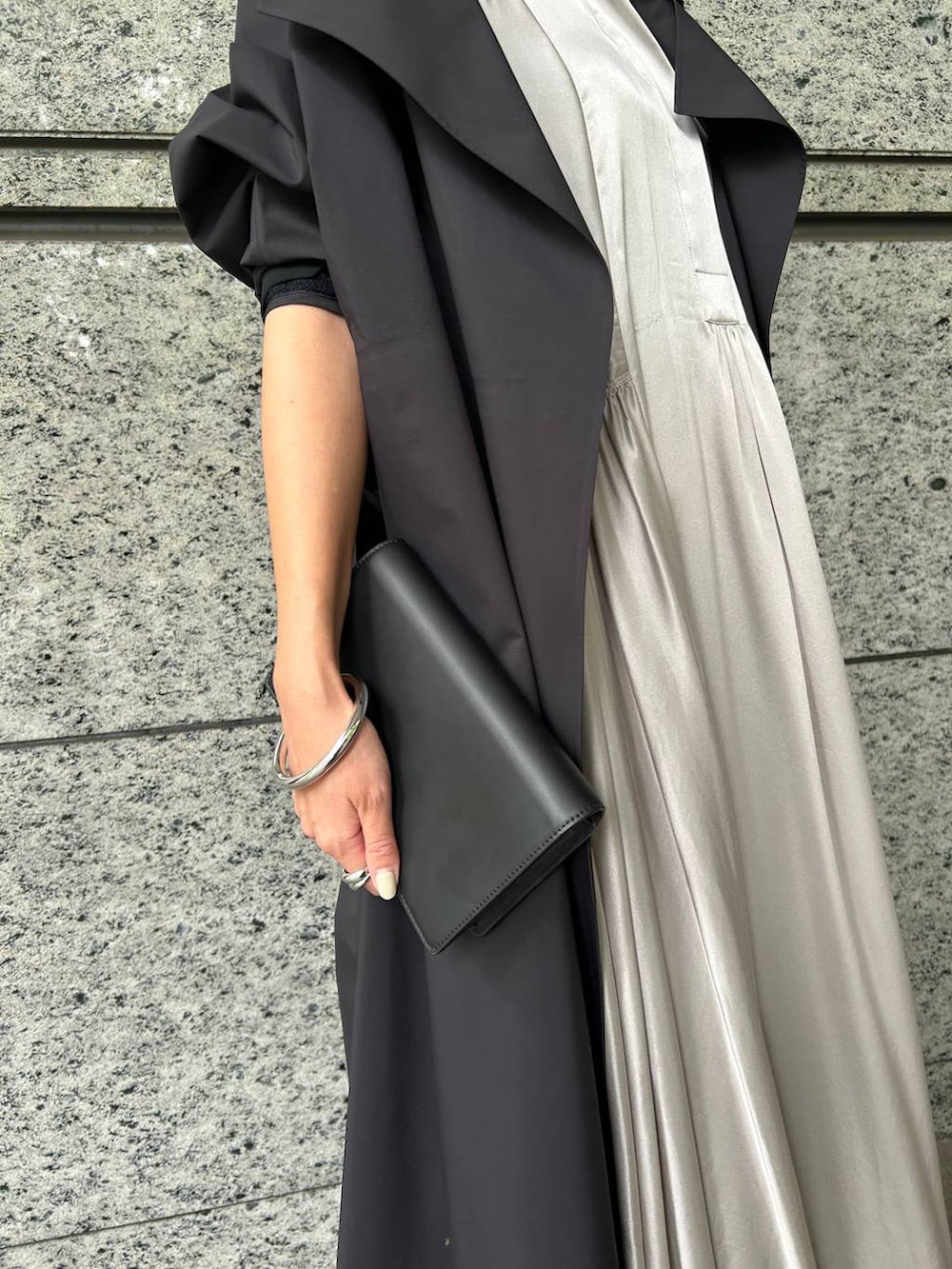 ブラック系のトレンチコート、グレー系のワンピースを着用したレディースの秋コーディネートの5枚目の写真