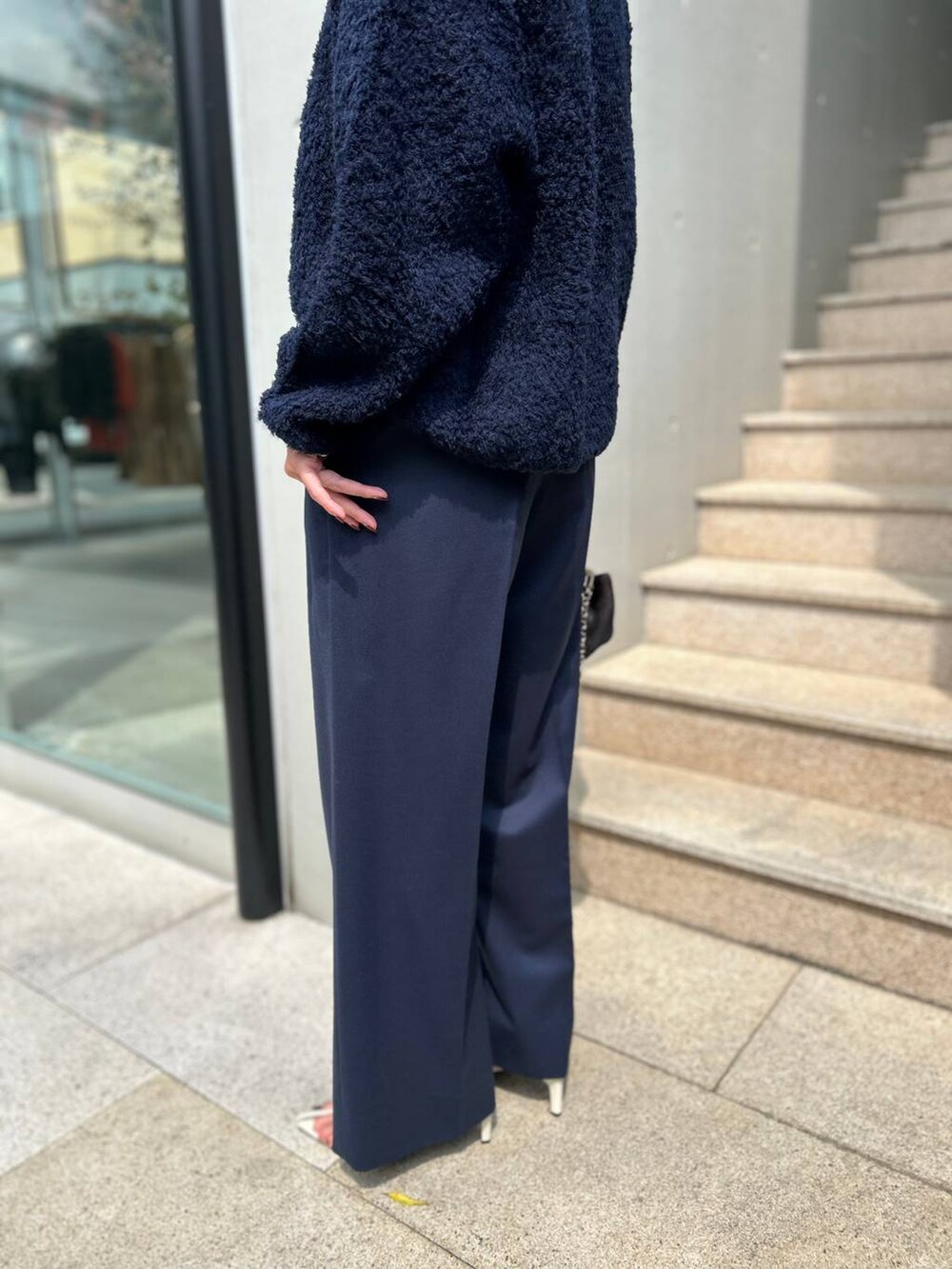 ブルー系のニット/セーター、ホワイト系のその他トップス、ブルー系のスラックスを着用したレディースの秋コーディネートの9枚目の写真