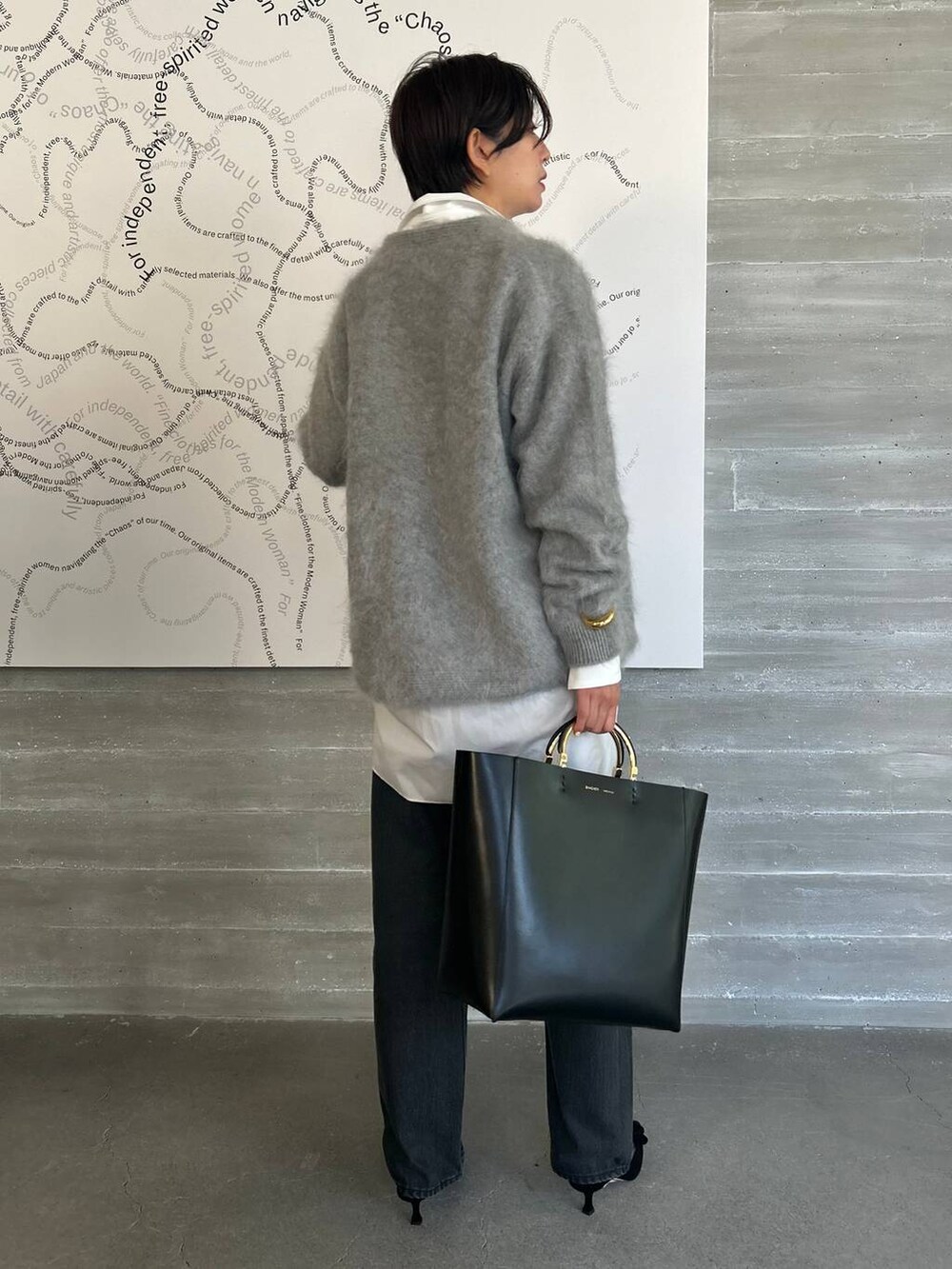ブラック系のデニムパンツ、ホワイト系のシャツ/ブラウス、グレー系のカーディガン/ボレロを着用したレディースの夏コーディネートの2枚目の写真