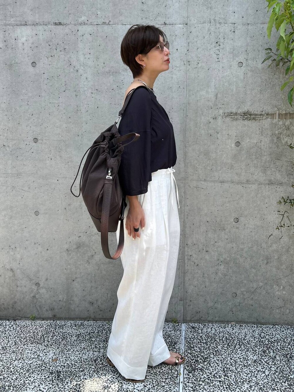 ブラック系のチューブトップ、ホワイト系のスラックス、グレー系のTシャツ/カットソーを着用したレディースの春コーディネートの3枚目の写真