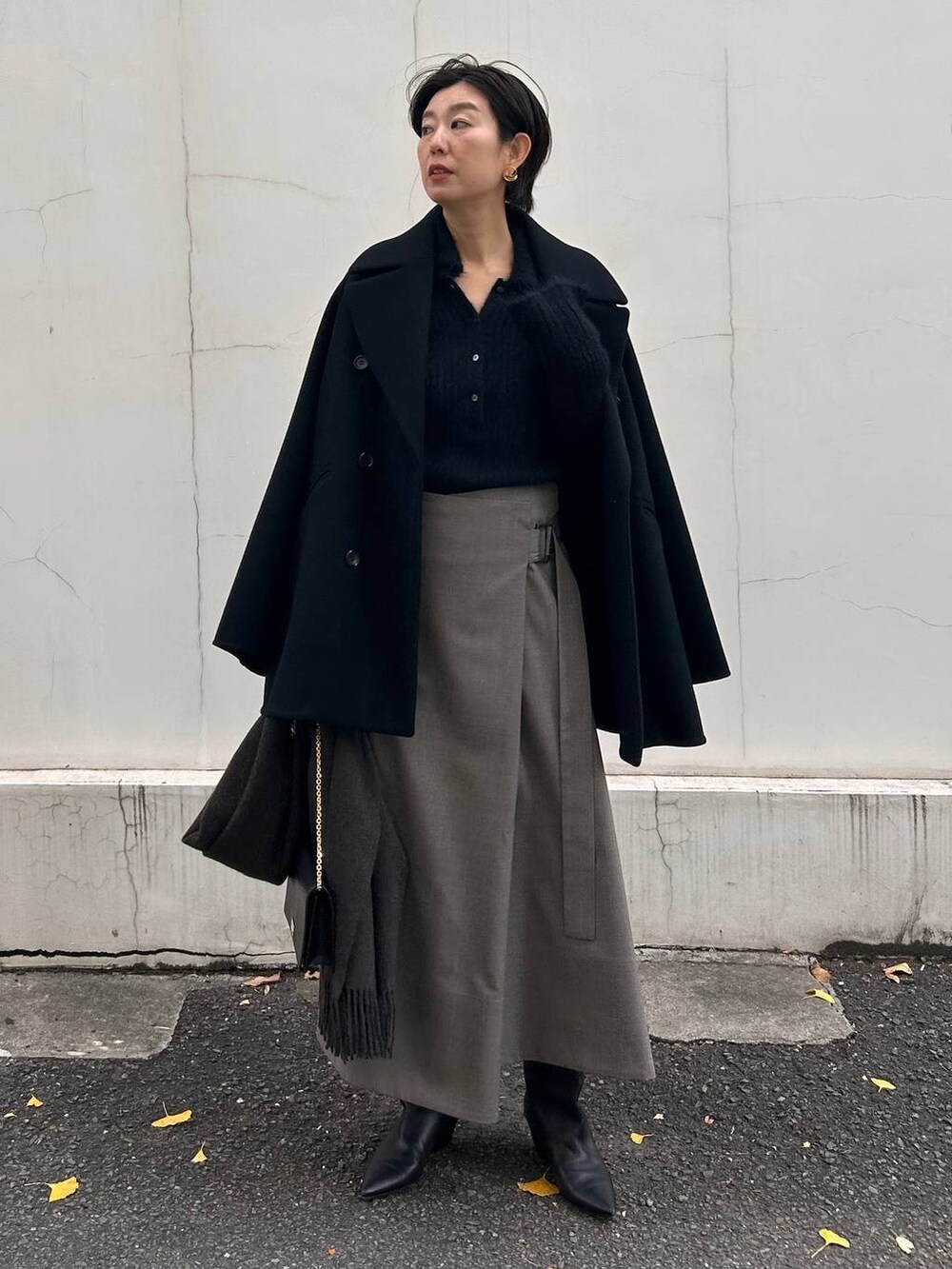 ブラック系のニット/セーター、ベージュ系のスカート、ブラウン系のストール/ショールを着用したレディースの冬コーディネートの6枚目の写真