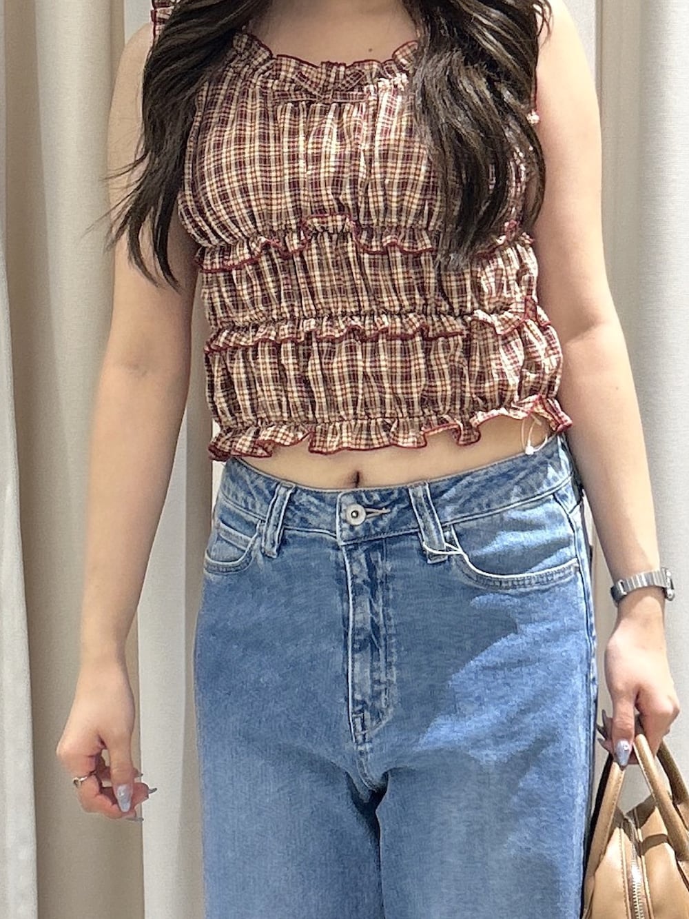 レッド系のシャツ/ブラウス、ブルー系のデニムパンツ、ブラウン系のハンドバッグを着用したレディースの夏コーディネートの4枚目の写真
