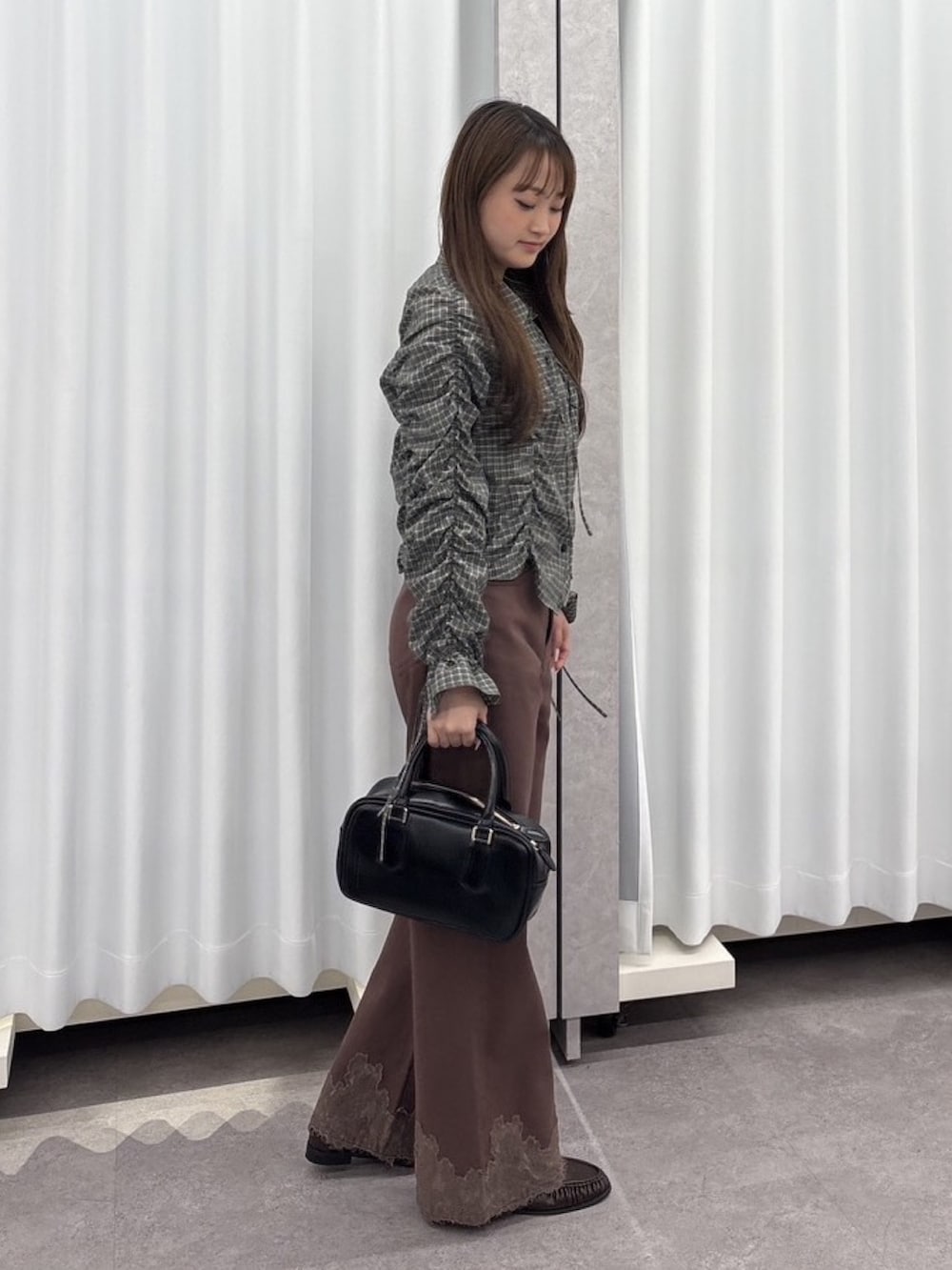 ブラック系のシャツ/ブラウス、ブラウン系のデニムパンツ、ブラック系のハンドバッグを着用したレディースの秋コーディネートの2枚目の写真