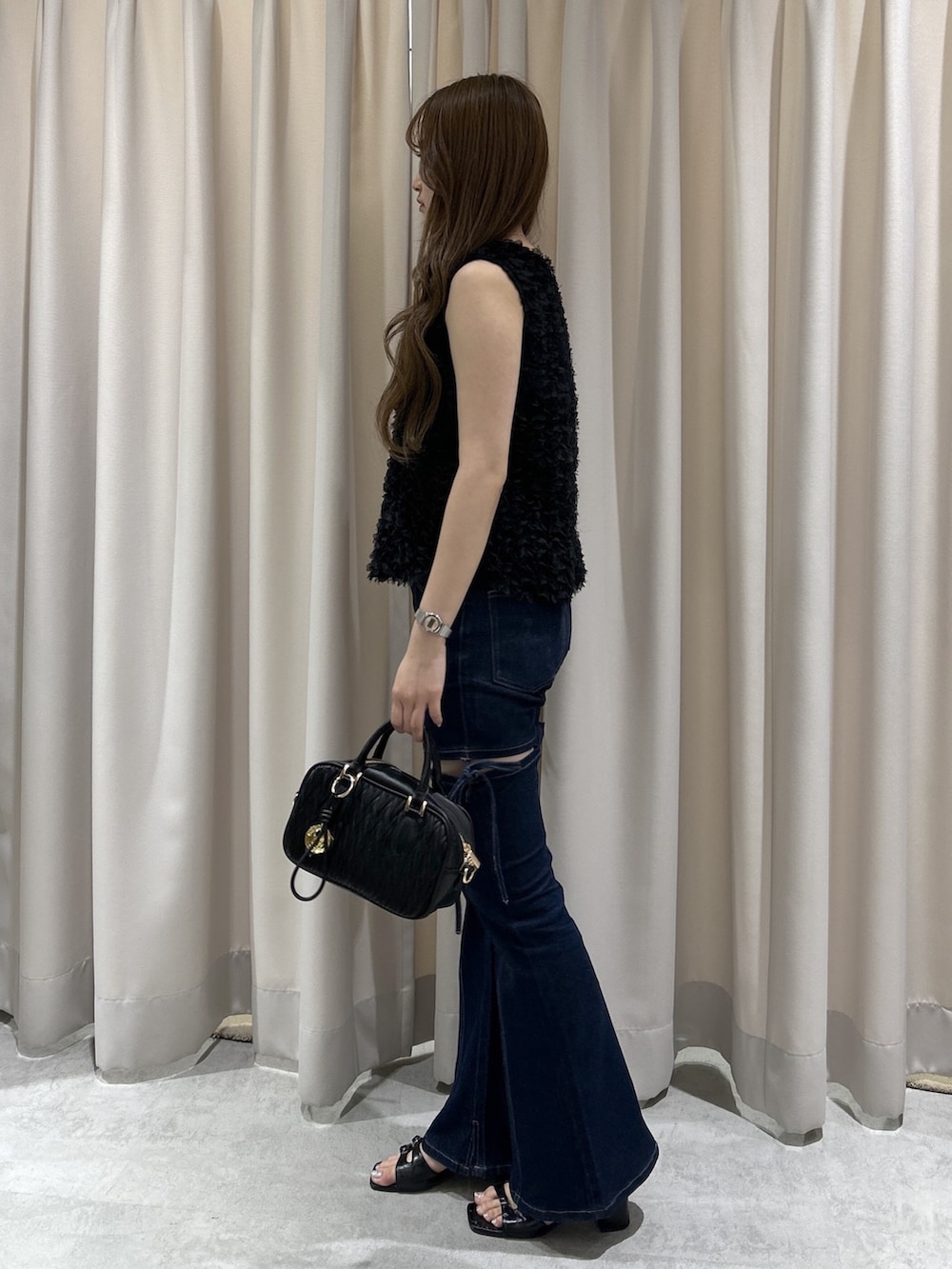 ブルー系のデニムパンツ、ブラック系のボストンバッグ、ブラック系のシャツ/ブラウスを着用したレディースの夏コーディネートの2枚目の写真