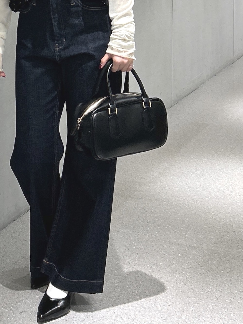 ブラック系のシャツ/ブラウス、ホワイト系のTシャツ/カットソー、ブルー系のデニムパンツを着用したレディースの春コーディネートの5枚目の写真