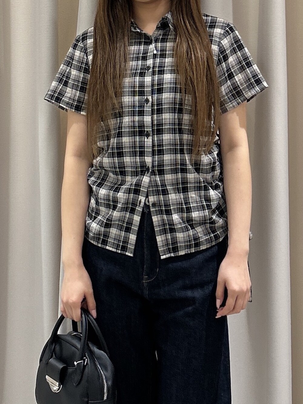 ブルー系のデニムパンツ、ブラック系のシャツ/ブラウス、ブラック系のハンドバッグを着用したレディースの夏コーディネートの5枚目の写真