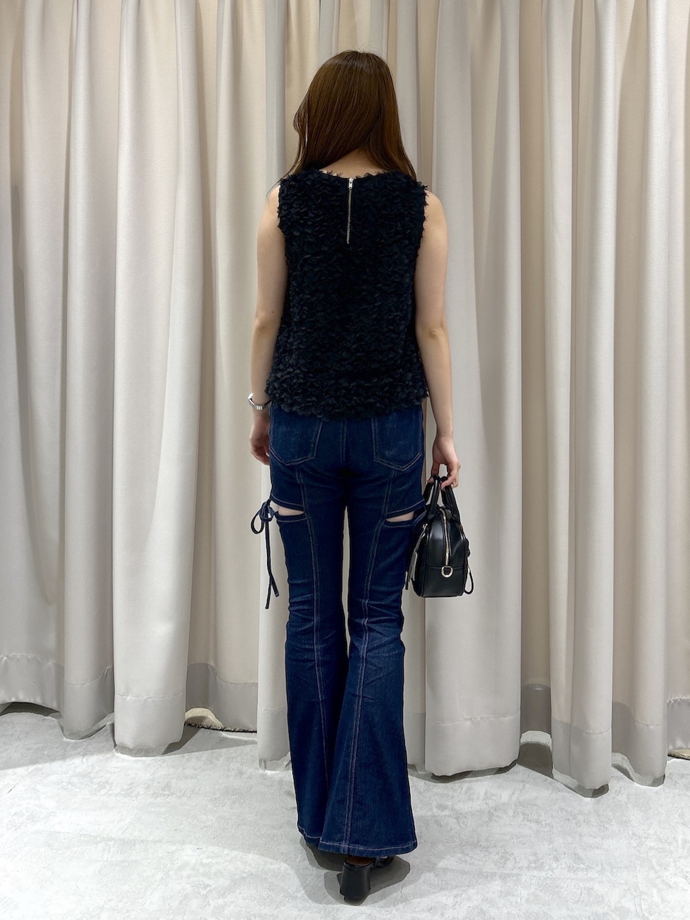 ブルー系のデニムパンツ、ブラック系のボストンバッグ、ブラック系のシャツ/ブラウスを着用したレディースの夏コーディネートの3枚目の写真