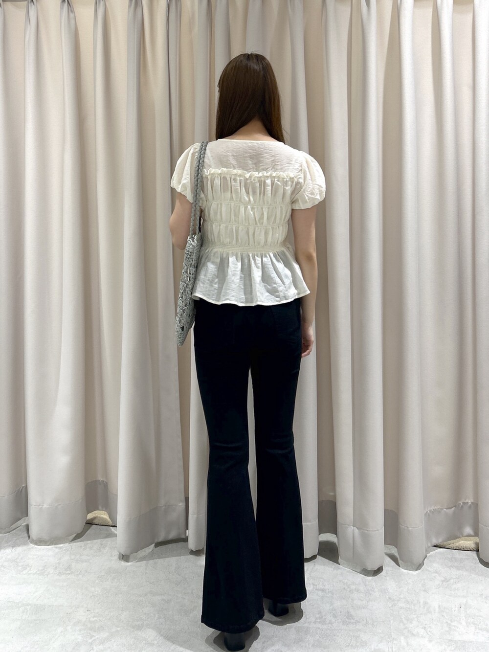 ブラック系のデニムパンツ、ホワイト系のシャツ/ブラウス、グリーン系のトートバッグを着用したレディースの夏コーディネートの4枚目の写真