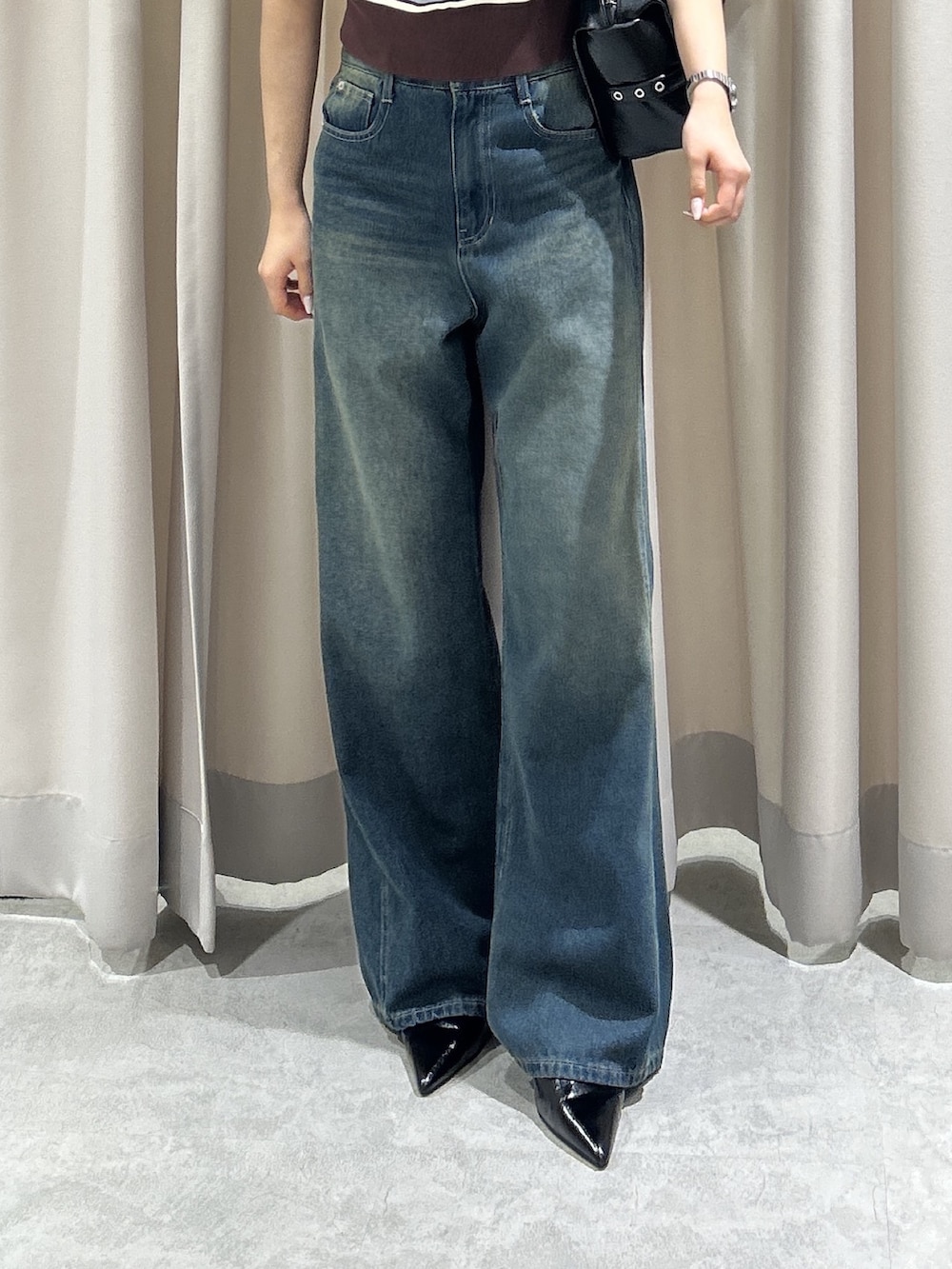 ブラウン系のニット/セーター、ブルー系のデニムパンツ、ブラック系のショルダーバッグを着用したレディースの夏コーディネートの5枚目の写真