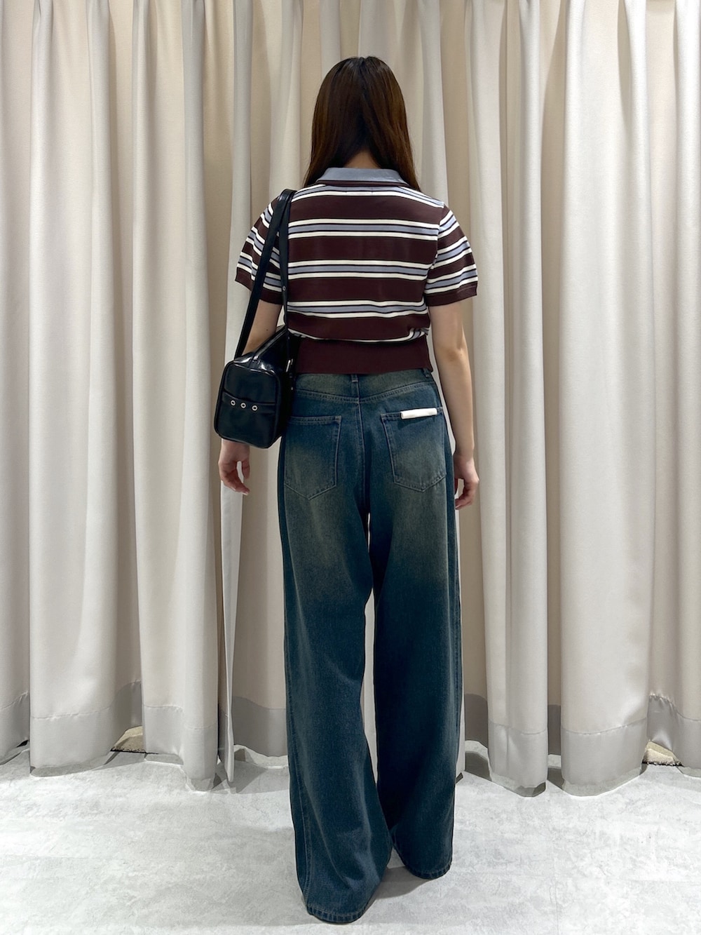 ブラウン系のニット/セーター、ブルー系のデニムパンツ、ブラック系のショルダーバッグを着用したレディースの夏コーディネートの4枚目の写真