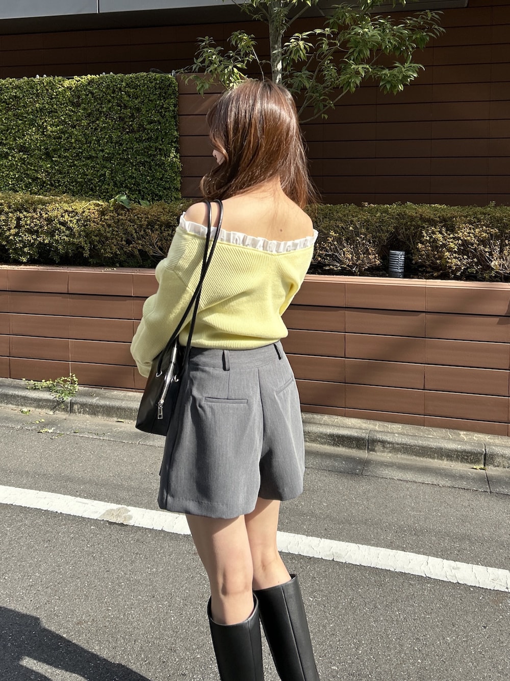 イエロー系のニット/セーター、ブラック系のショルダーバッグを着用したレディースの春コーディネートの4枚目の写真