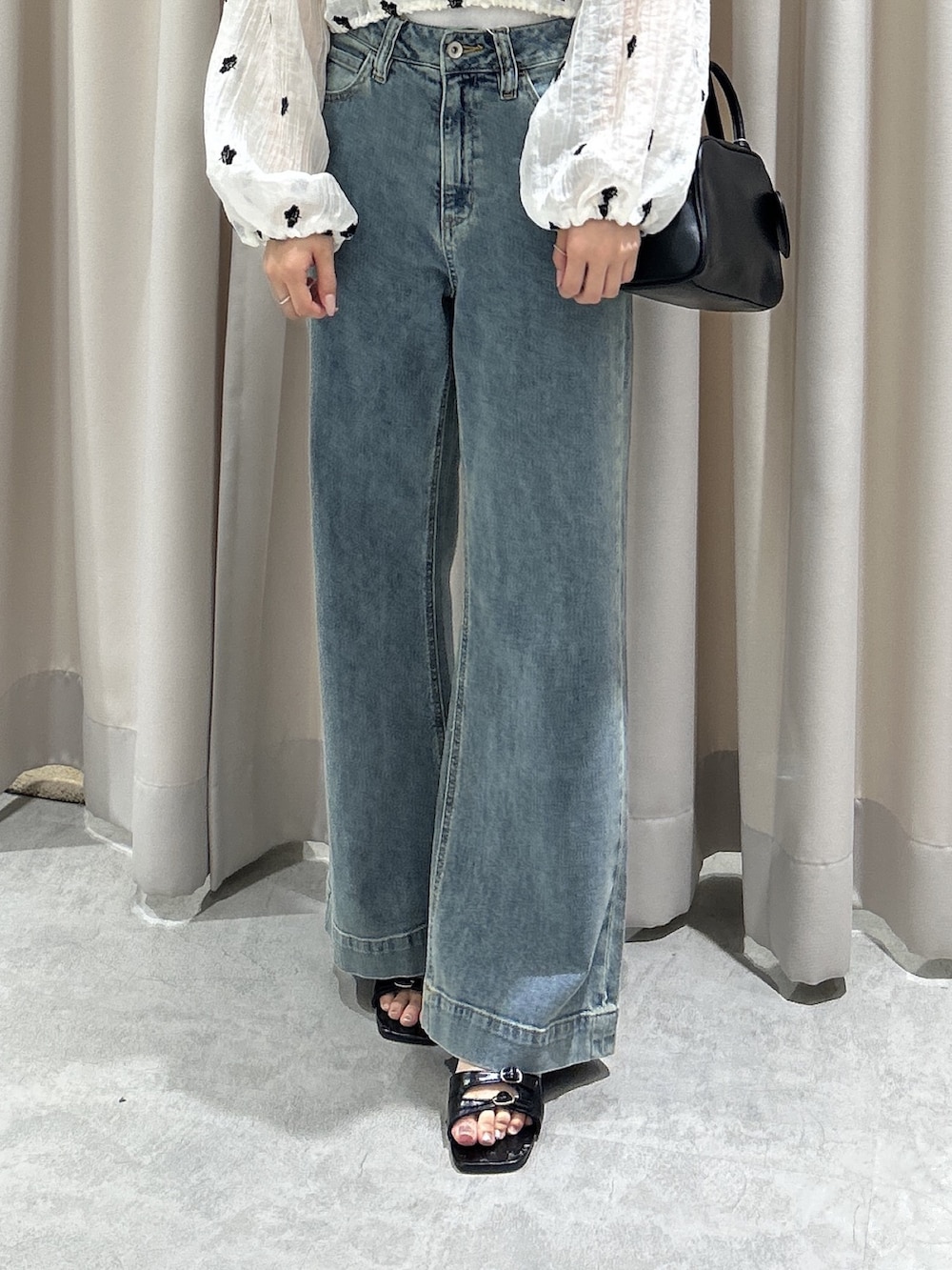 ブルー系のデニムパンツ、ホワイト系のシャツ/ブラウス、ブラック系のサンダルを着用したレディースの夏コーディネートの5枚目の写真