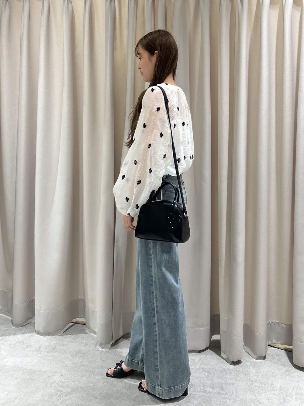 ブルー系のデニムパンツ、ホワイト系のシャツ/ブラウス、ブラック系のサンダルを着用したレディースの夏コーディネートの2枚目の写真