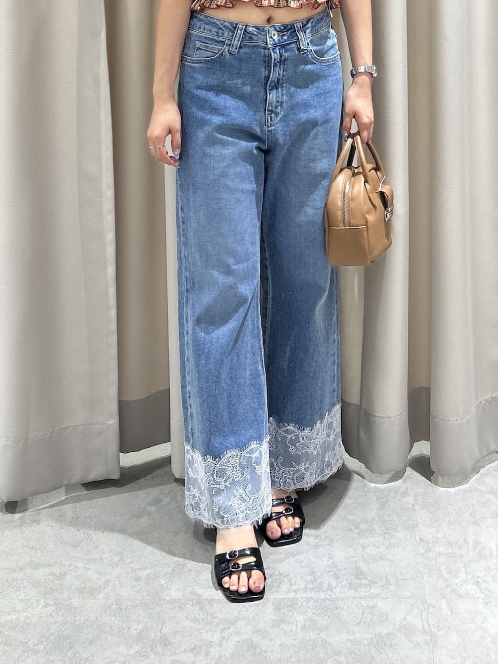 レッド系のシャツ/ブラウス、ブルー系のデニムパンツ、ブラウン系のハンドバッグを着用したレディースの夏コーディネートの5枚目の写真
