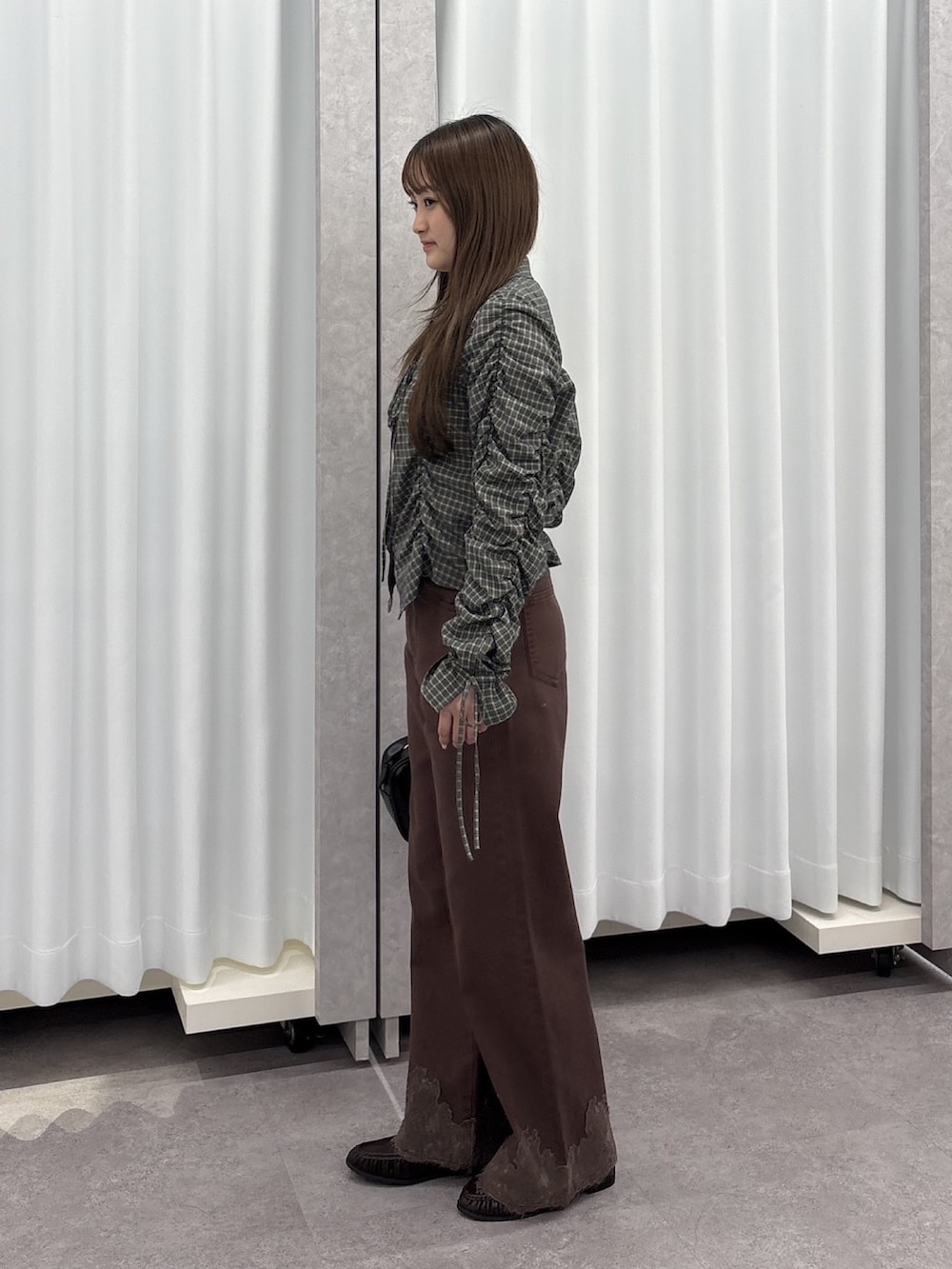 ブラック系のシャツ/ブラウス、ブラウン系のデニムパンツ、ブラック系のハンドバッグを着用したレディースの秋コーディネートの3枚目の写真