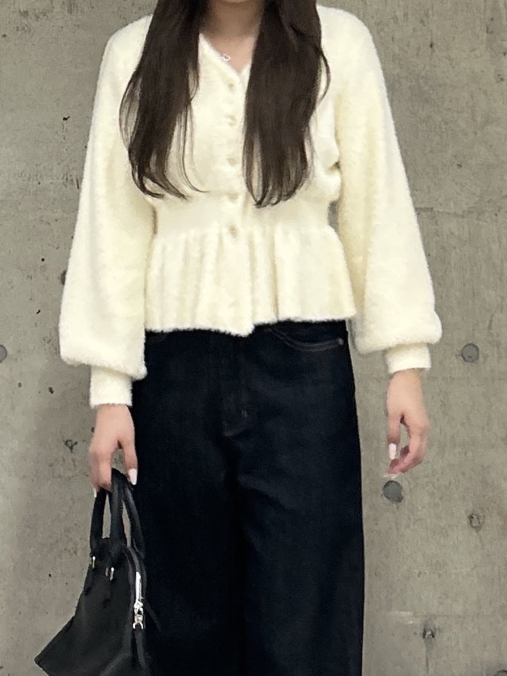 ホワイト系のニット/セーター、ブルー系のデニムパンツ、ブラック系のショルダーバッグを着用したレディースの秋コーディネートの4枚目の写真
