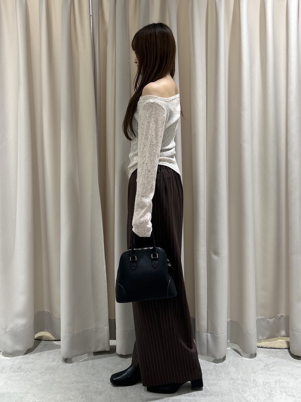 ブラウン系のTシャツ/カットソー、ブラウン系のスラックス、ブラック系のショルダーバッグを着用したレディースの秋コーディネートの3枚目の写真