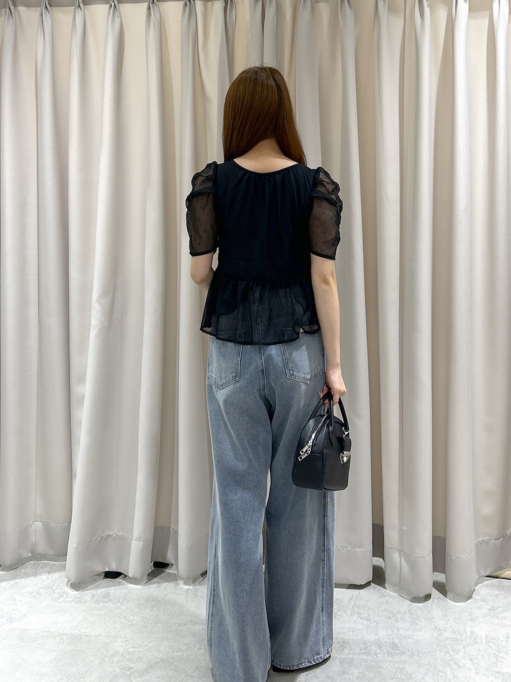 ブラック系のシャツ/ブラウス、ブルー系のデニムパンツ、ブラック系のハンドバッグを着用したレディースの夏コーディネートの4枚目の写真
