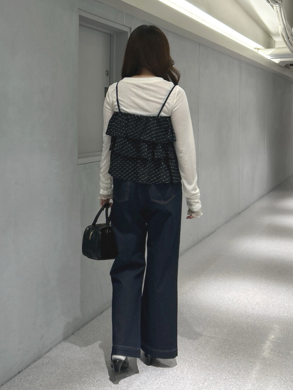 ブラック系のシャツ/ブラウス、ホワイト系のTシャツ/カットソー、ブルー系のデニムパンツを着用したレディースの春コーディネートの3枚目の写真