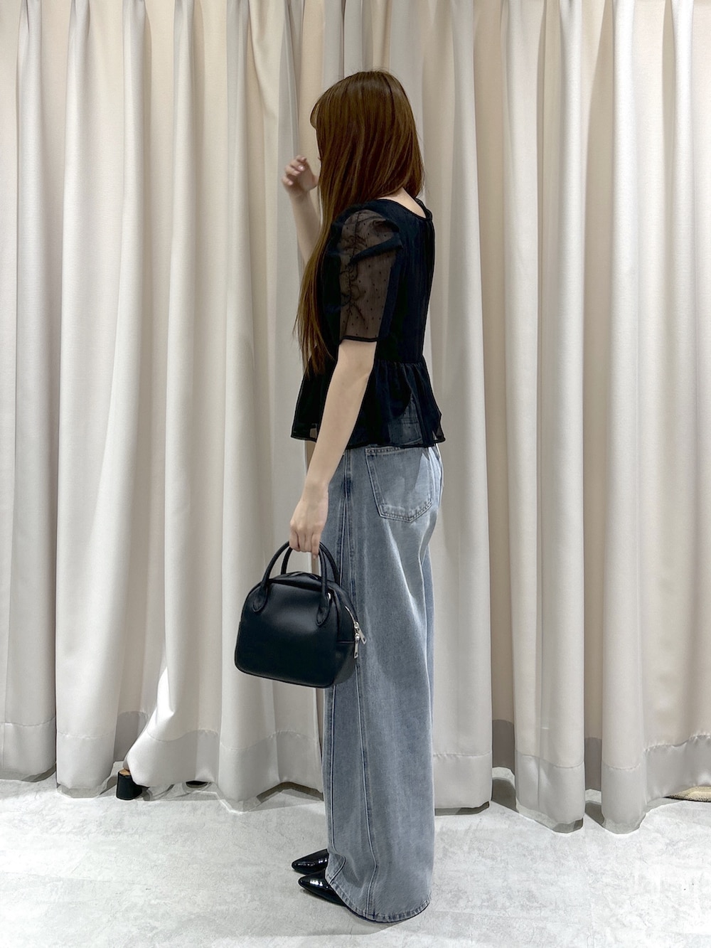 ブラック系のシャツ/ブラウス、ブルー系のデニムパンツ、ブラック系のハンドバッグを着用したレディースの夏コーディネートの3枚目の写真