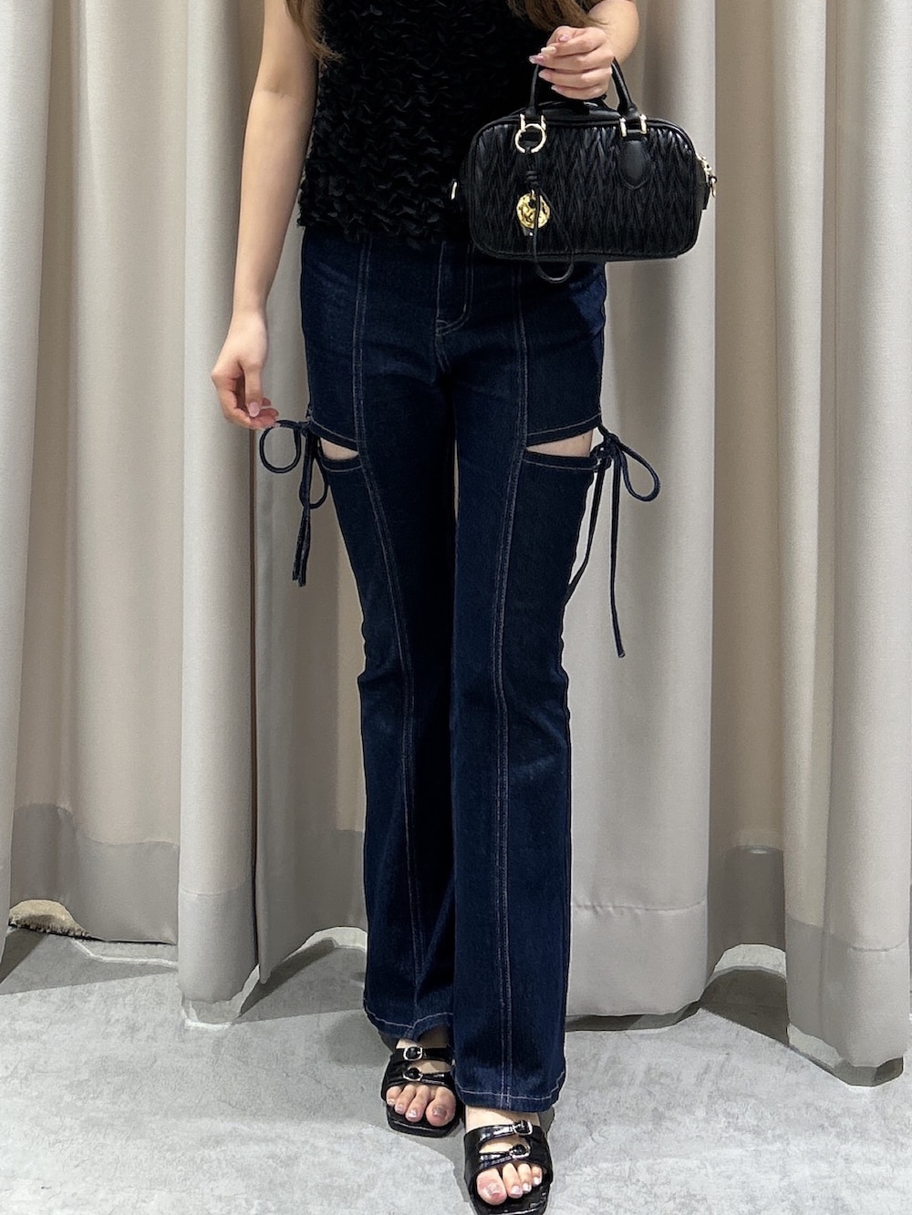 ブルー系のデニムパンツ、ブラック系のボストンバッグ、ブラック系のシャツ/ブラウスを着用したレディースの夏コーディネートの4枚目の写真