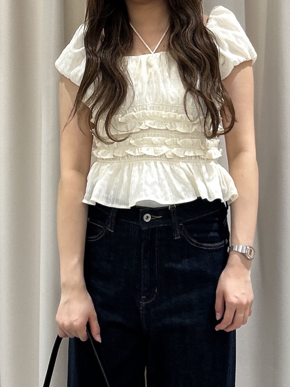 ブルー系のデニムパンツ、ブラック系のハンドバッグ、ホワイト系のシャツ/ブラウスを着用したレディースの春コーディネートの4枚目の写真