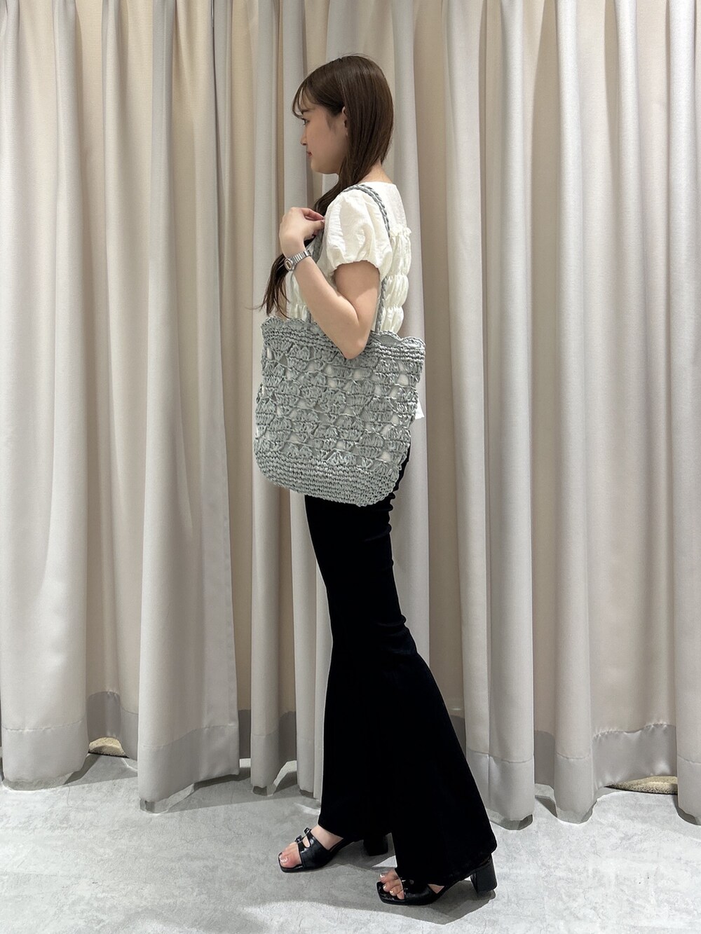 ブラック系のデニムパンツ、ホワイト系のシャツ/ブラウス、グリーン系のトートバッグを着用したレディースの夏コーディネートの3枚目の写真