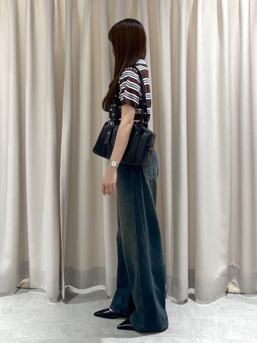 ブラウン系のニット/セーター、ブルー系のデニムパンツ、ブラック系のショルダーバッグを着用したレディースの夏コーディネートの2枚目の写真