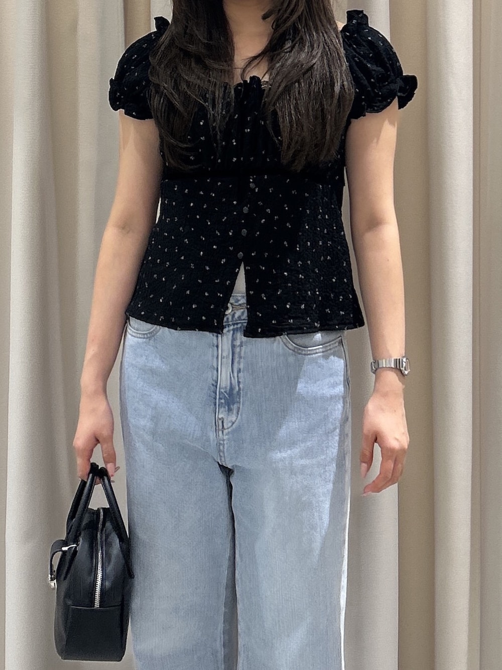 ブルー系のデニムパンツ、ブラック系のTシャツ/カットソー、ブラック系のハンドバッグを着用したレディースの夏コーディネートの5枚目の写真