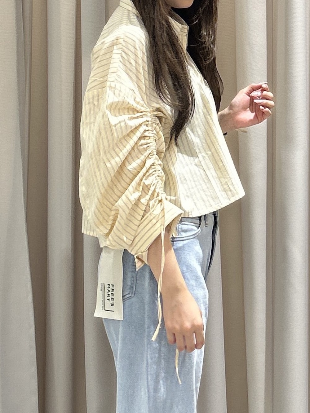 ホワイト系のシャツ/ブラウス、ブラック系のショルダーバッグ、ブルー系のデニムパンツを着用したレディースの秋コーディネートの4枚目の写真