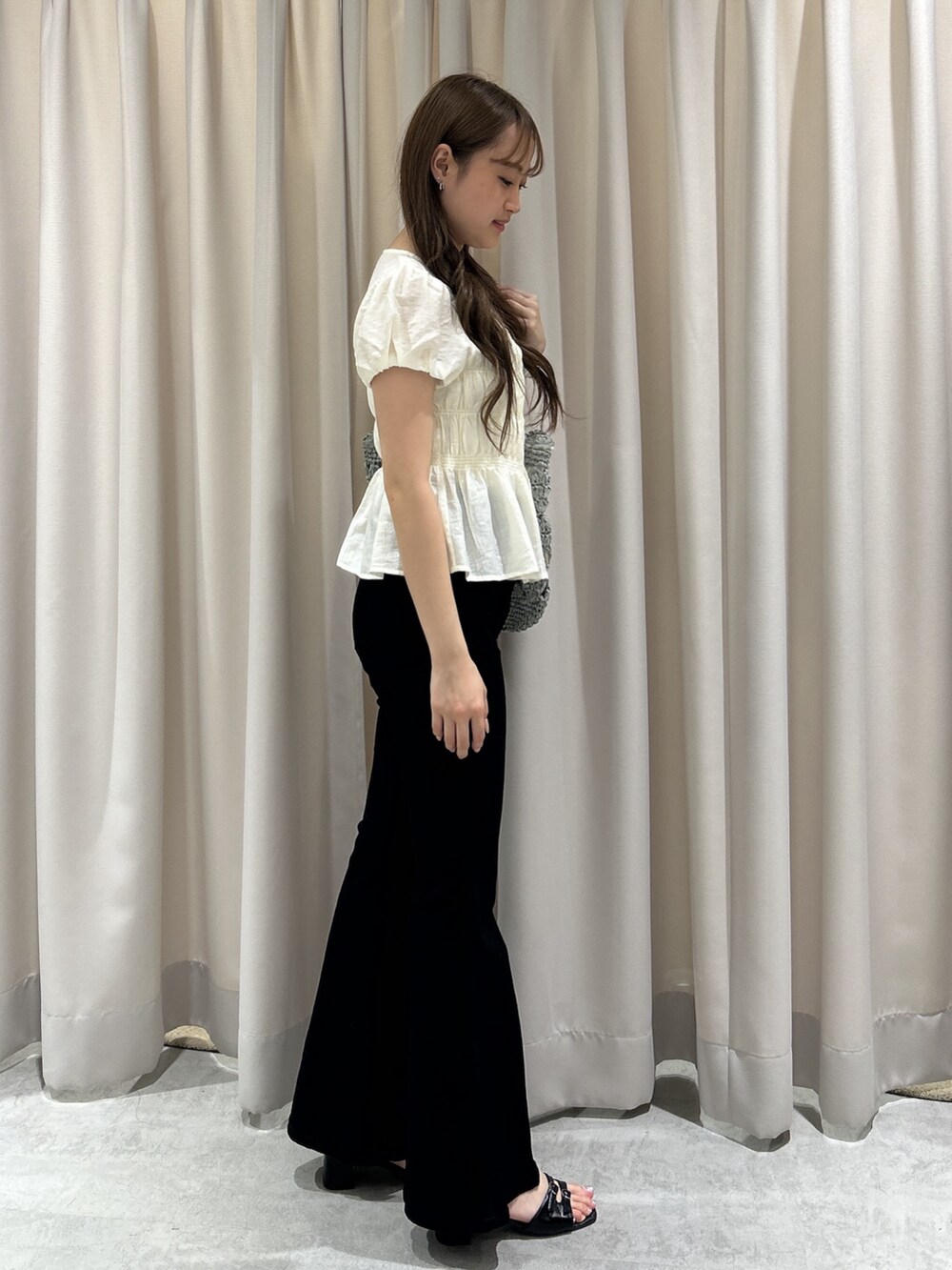 ブラック系のデニムパンツ、ホワイト系のシャツ/ブラウス、グリーン系のトートバッグを着用したレディースの夏コーディネートの2枚目の写真
