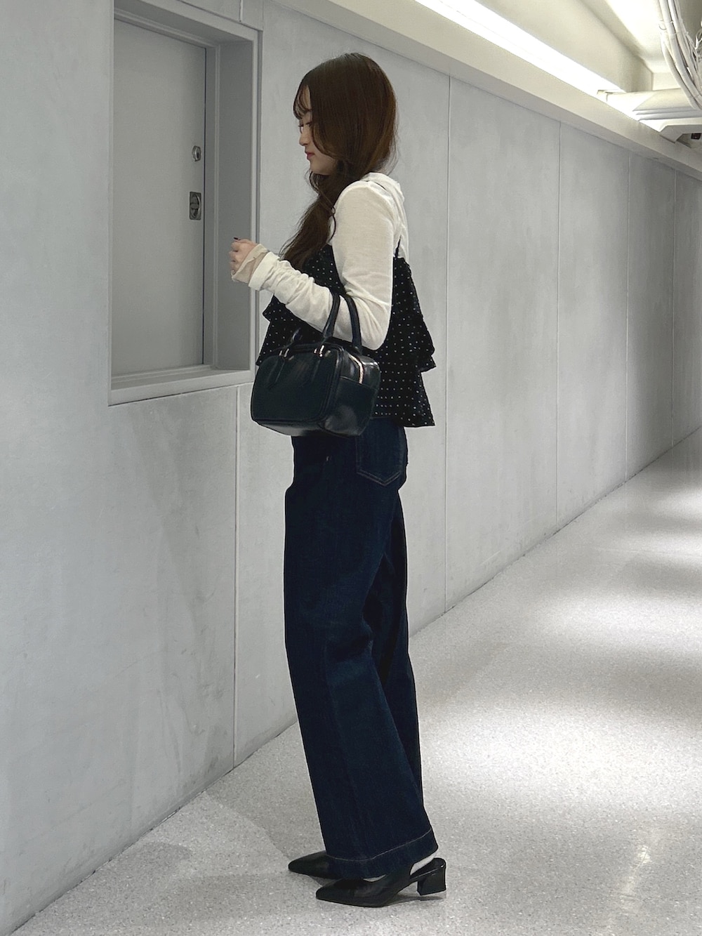 ブラック系のシャツ/ブラウス、ホワイト系のTシャツ/カットソー、ブルー系のデニムパンツを着用したレディースの春コーディネートの2枚目の写真