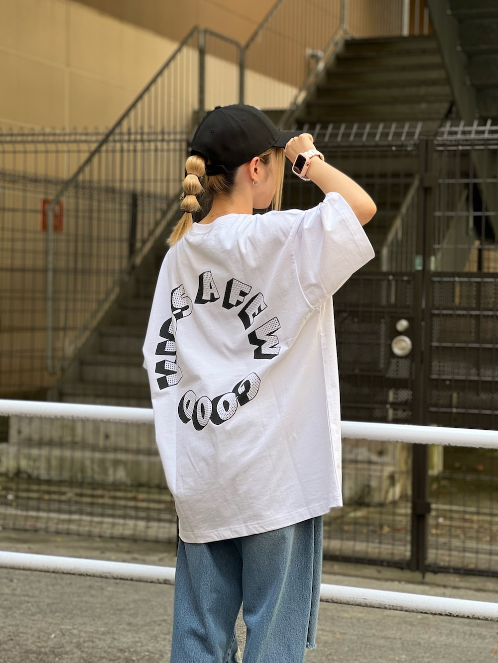ホワイト系のTシャツ/カットソー、ブルー系のデニムパンツ、ブラック系のキャップを着用したレディースの夏コーディネートの2枚目の写真