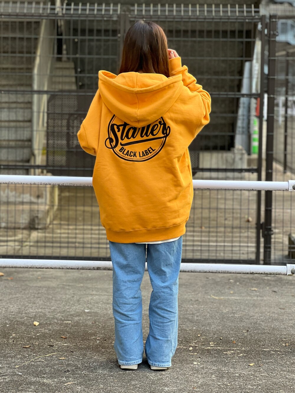 イエロー系のパーカーを着用したレディースの春コーディネートの2枚目の写真