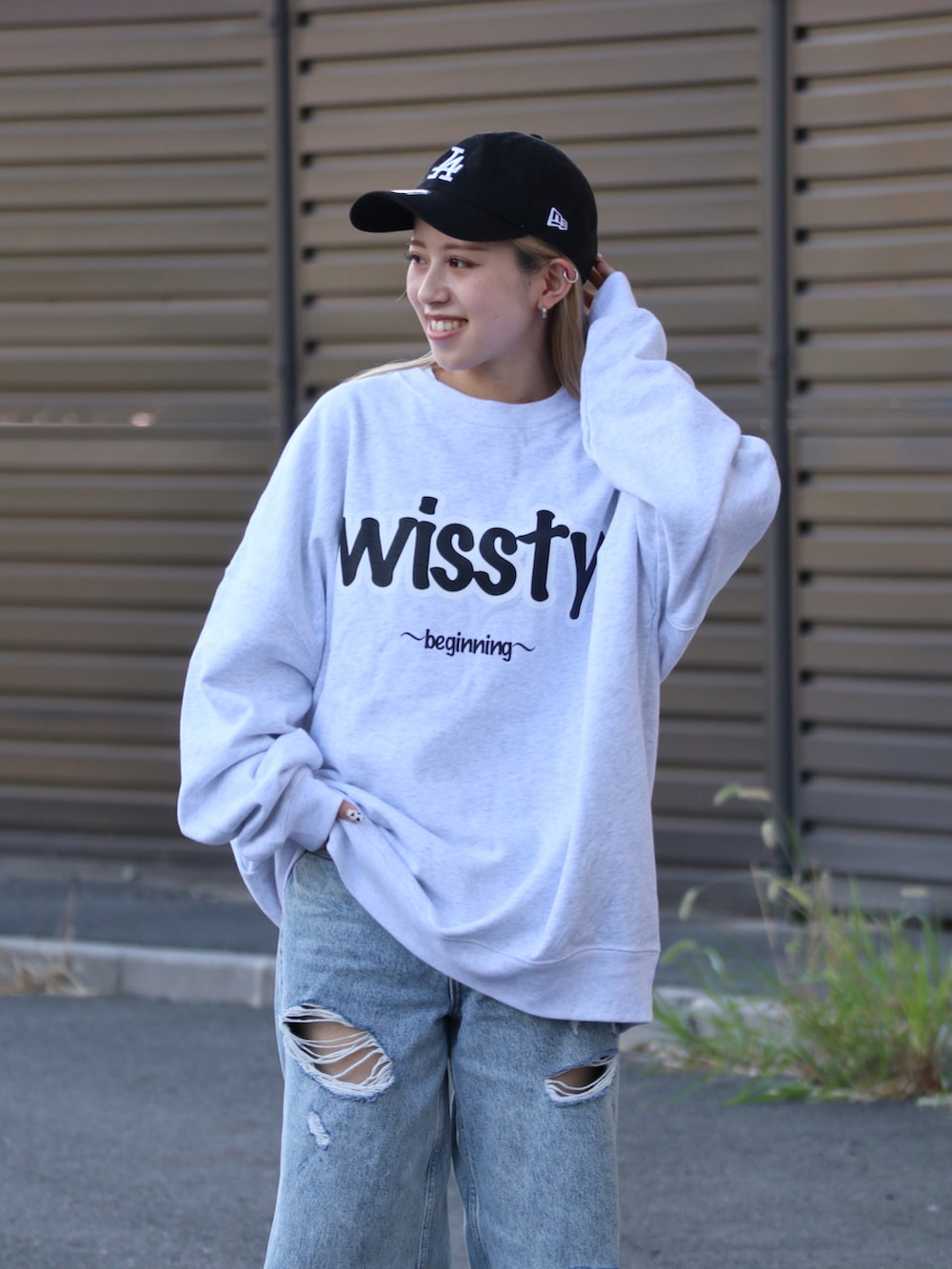 グレー系のスウェット、ブルー系のデニムパンツを着用したレディースの秋コーディネートの2枚目の写真