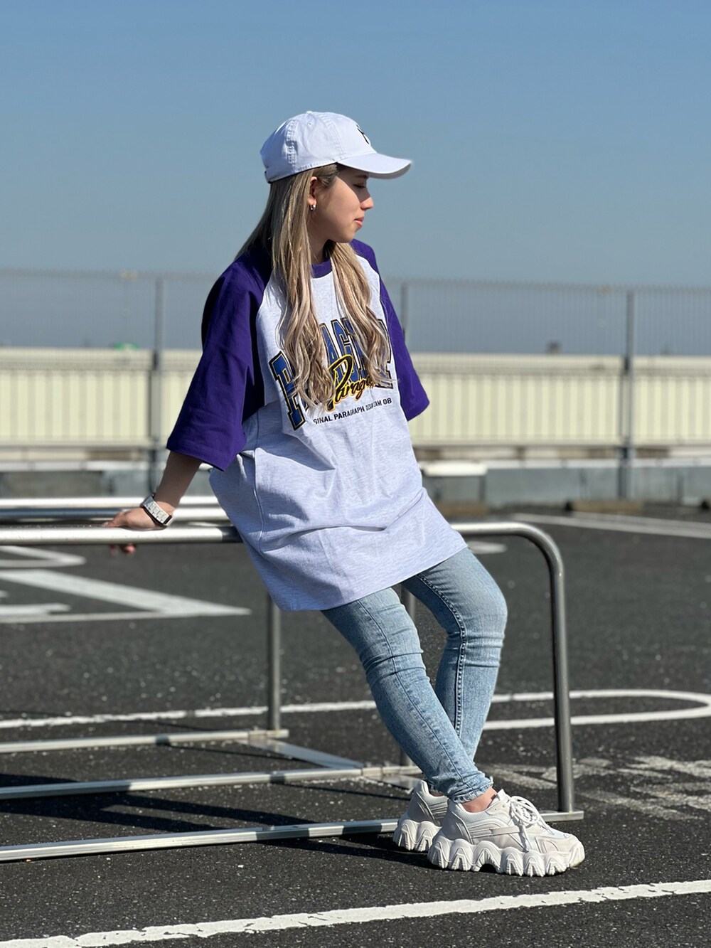 パープル系のTシャツ/カットソー、ブルー系のデニムパンツ、ホワイト系のスニーカーを着用したレディースの春コーディネートの2枚目の写真