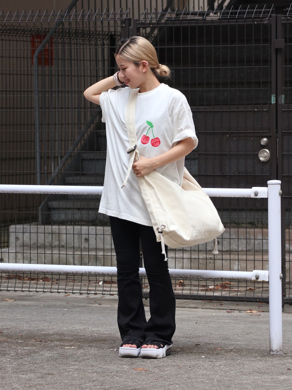 ホワイト系のTシャツ/カットソー、ブラック系のデニムパンツを着用したレディースの夏コーディネートの2枚目の写真