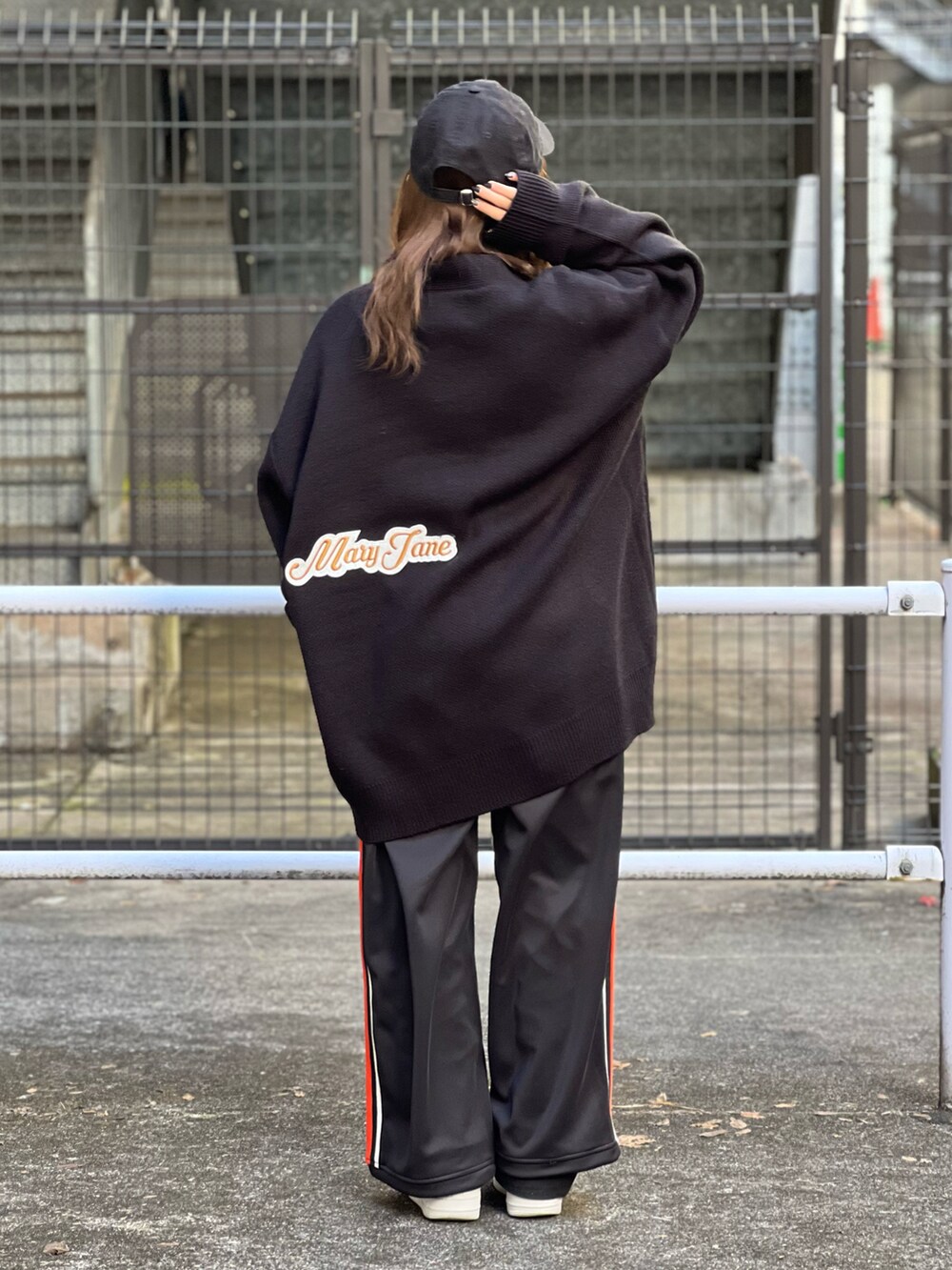 ブラック系のカーディガン/ボレロ、ブラック系のキャップを着用したレディースの冬コーディネートの2枚目の写真