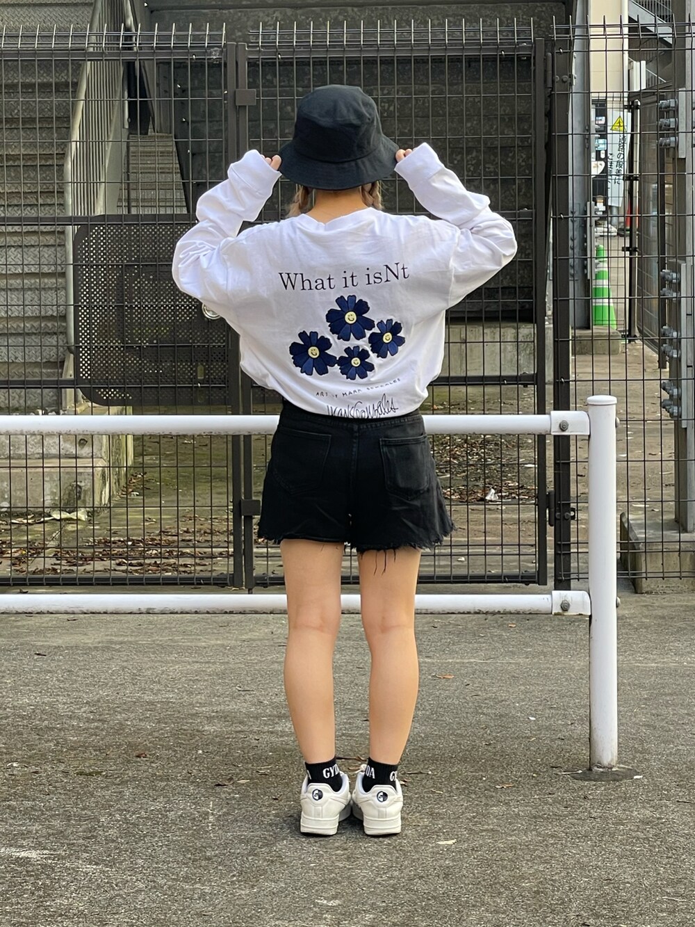 ホワイト系のTシャツ/カットソー、ブラック系のその他パンツ、ブラック系のハットを着用したレディースの秋コーディネートの2枚目の写真