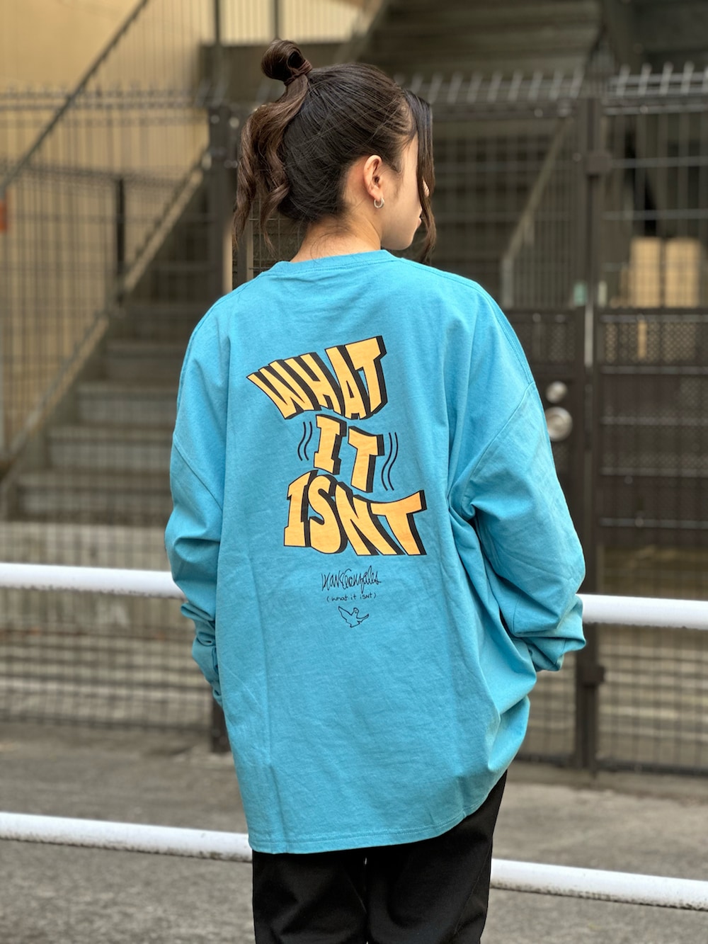 ブルー系のTシャツ/カットソー、ブラック系のチノパンツを着用したレディースの冬コーディネートの2枚目の写真