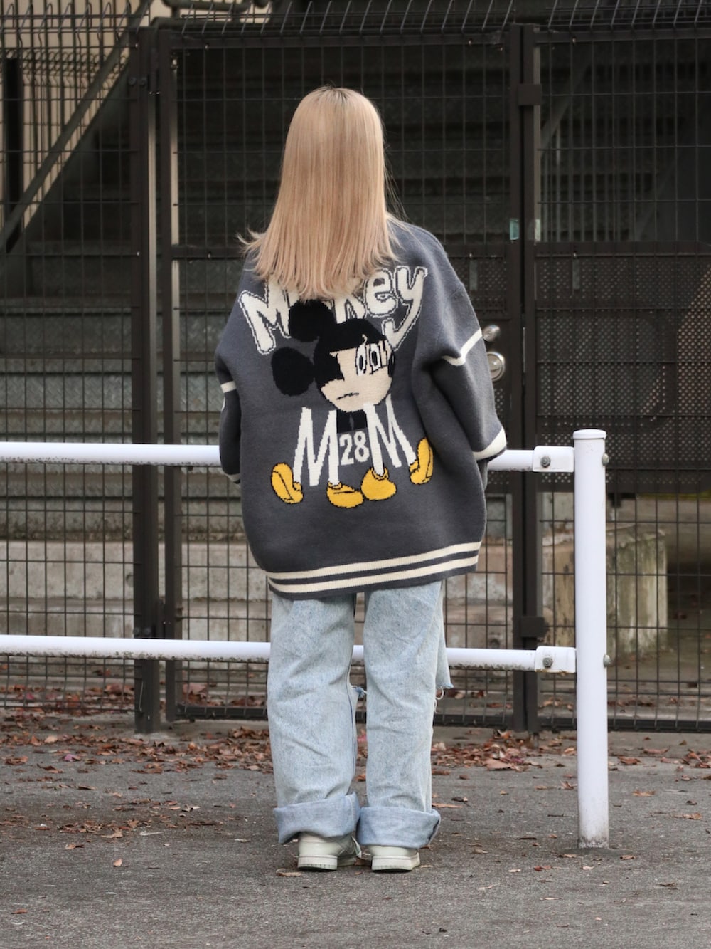 グレー系のニット/セーター、ブルー系のデニムパンツを着用したレディースの秋コーディネートの2枚目の写真