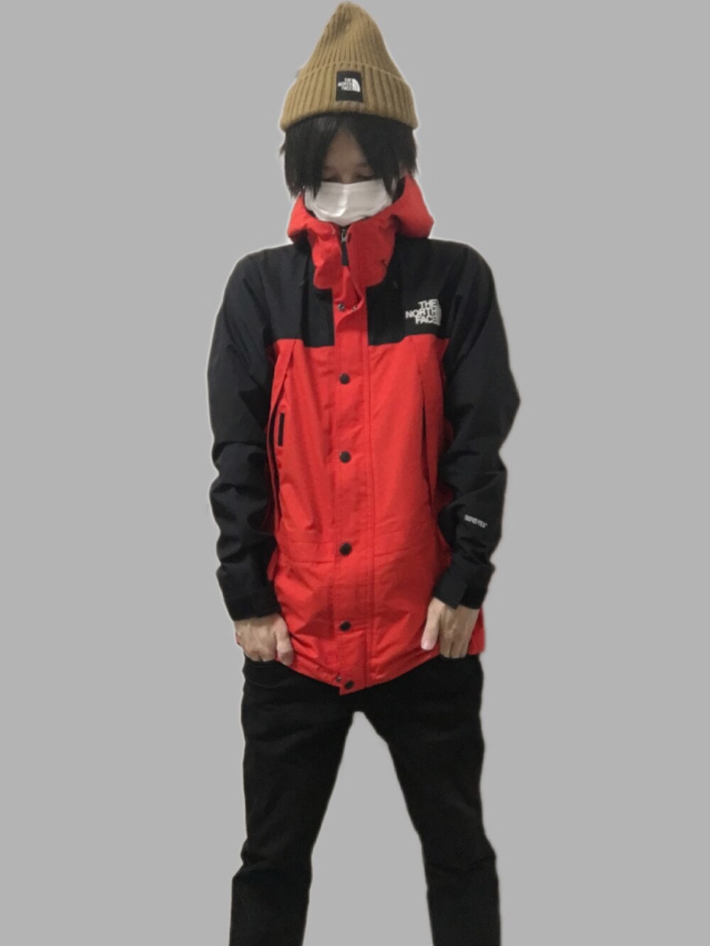 レッド系のマウンテンパーカー、ブラウン系のニットキャップ/ビーニーを着用したメンズの冬コーディネートの2枚目の写真