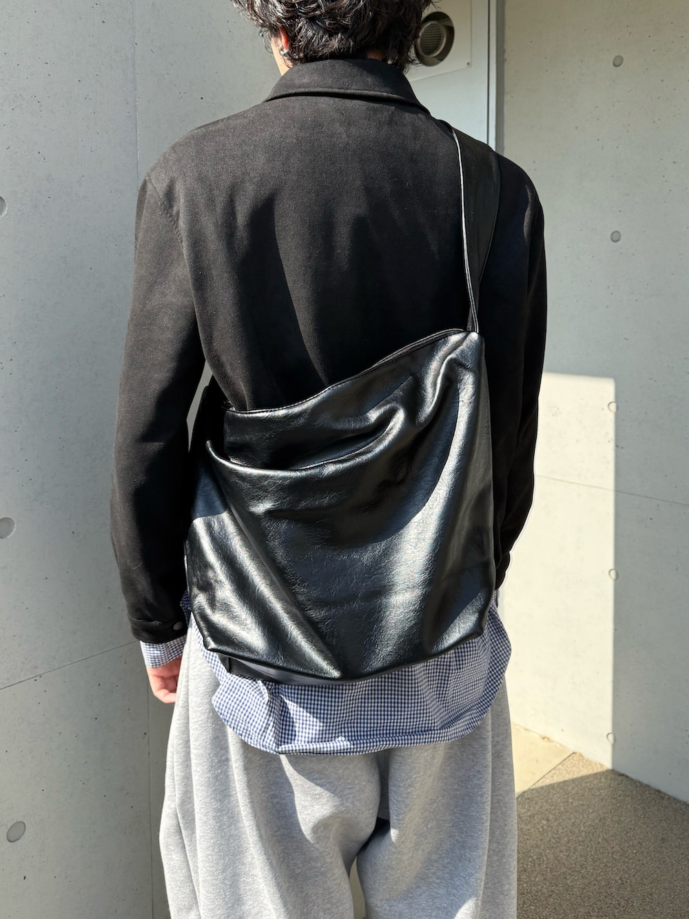 グレー系のスウェットパンツ、ブラック系のスニーカー、ブラック系のその他アウターを着用したメンズの春コーディネートの4枚目の写真