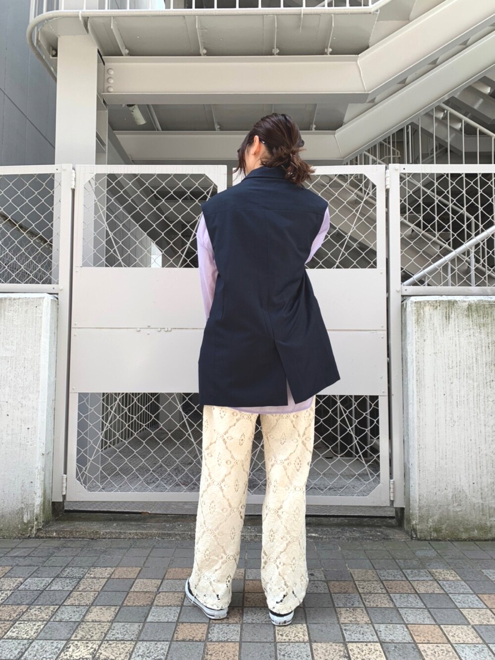 ブルー系のベスト、パープル系のシャツ/ブラウス、ホワイト系のその他パンツを着用したレディースの春コーディネートの2枚目の写真