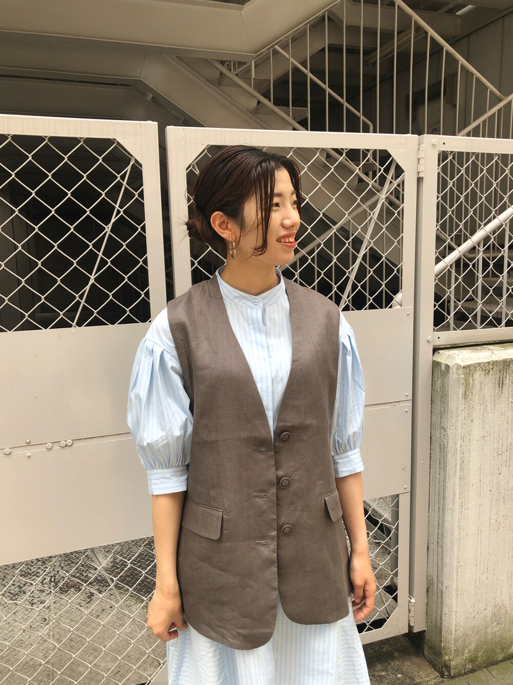ブルー系のワンピース、ベージュ系のベスト、ホワイト系のその他パンツを着用したレディースの春コーディネートの3枚目の写真