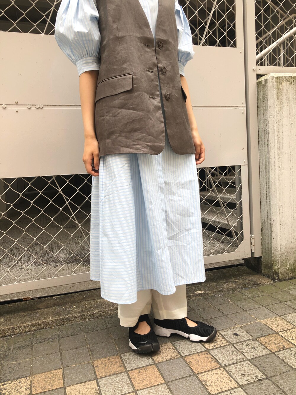 ブルー系のワンピース、ベージュ系のベスト、ホワイト系のその他パンツを着用したレディースの春コーディネートの4枚目の写真